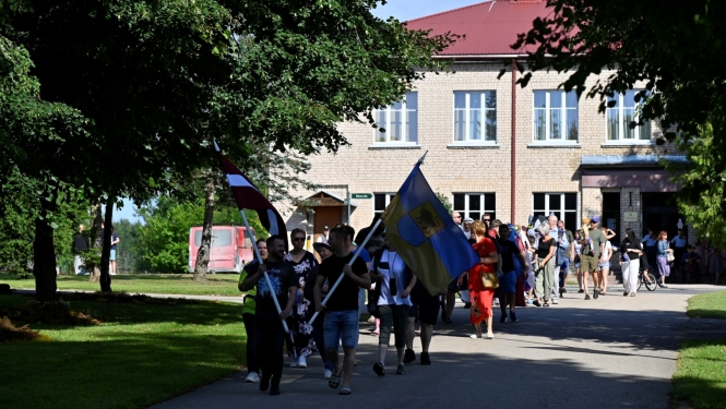 Svētku dalībnieki dodas tradicionālajā gājiena no Taurupes Tautas nama līdz skolai 