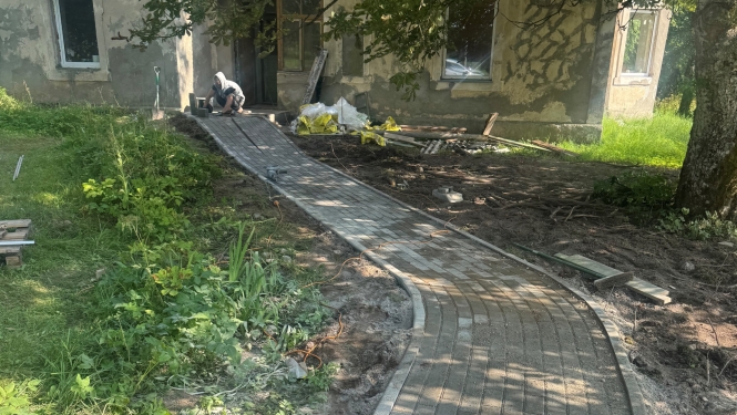 Tiek īstenots vides pieejamības nodrošināšanas projekts - tiek veikti bruģēta celiņa izveides darbi nokļūšanai ēkā