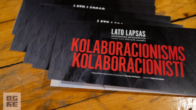 Izstādes bukleti - uz melna fona sarkans teksts: "Lato Lapsas zemzemes ekspedīcija “Kolaboracionisms un kolaboracionisti” Indrānu ielā 9, Ogrē, no 12. novembra