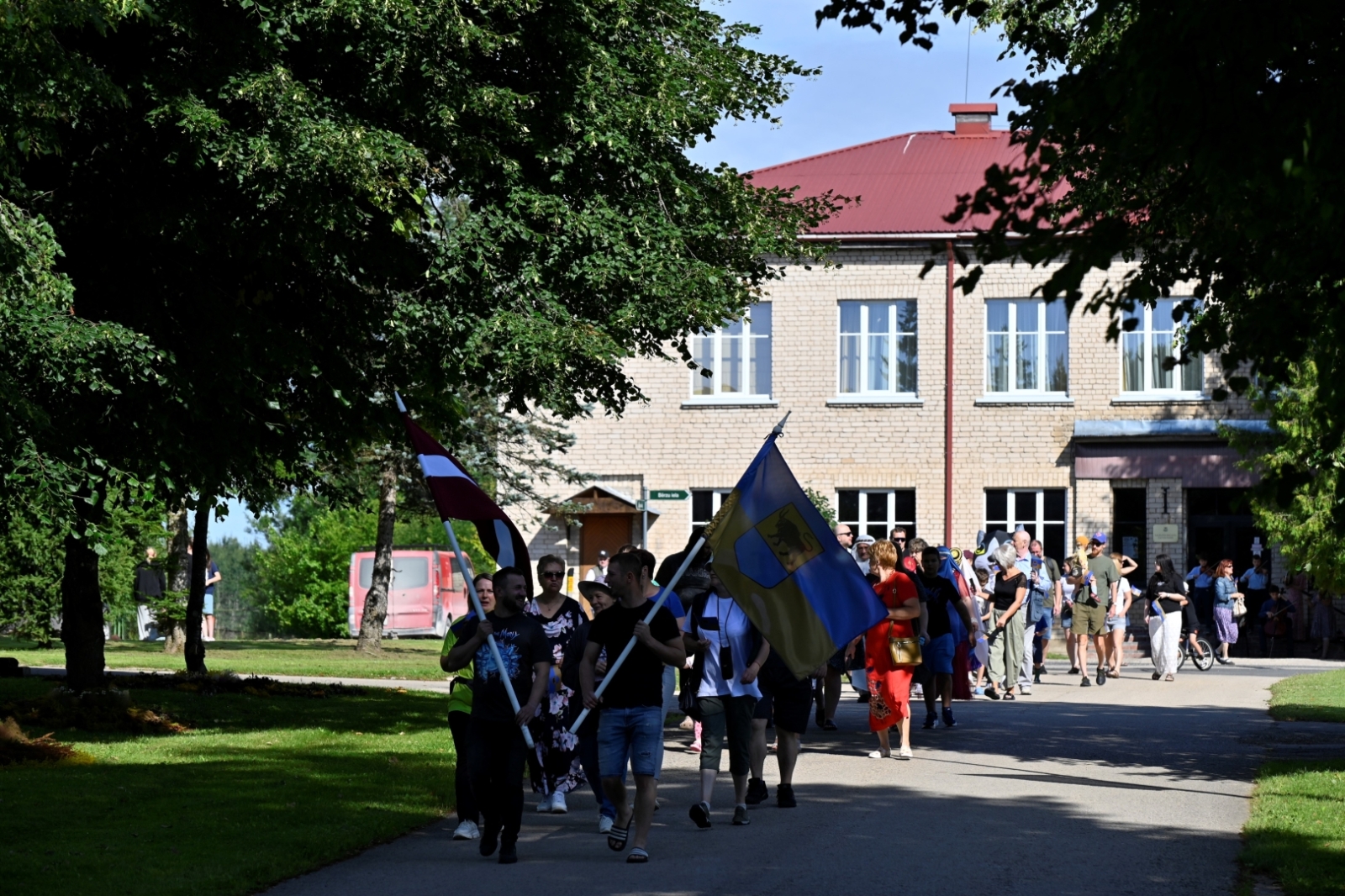 Svētku dalībnieki dodas tradicionālajā gājiena no Taurupes Tautas nama līdz skolai 
