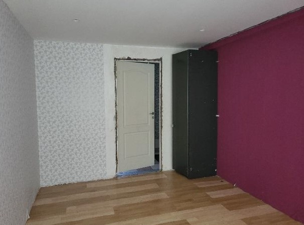 Istaba ar violetas krāsas sienu, durvīm un melnu skapi
