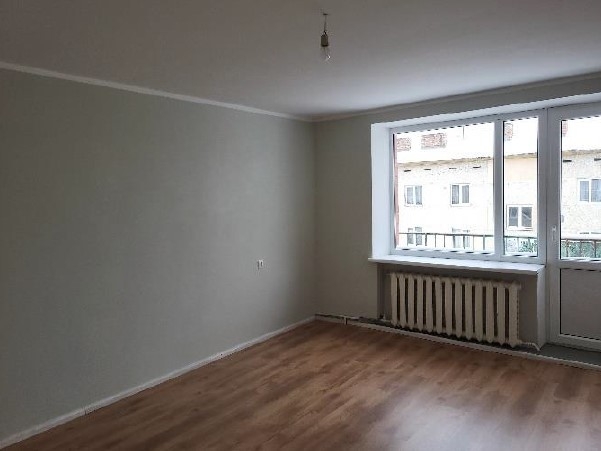 Istaba gaišos toņos ar logu un balkona durvīm