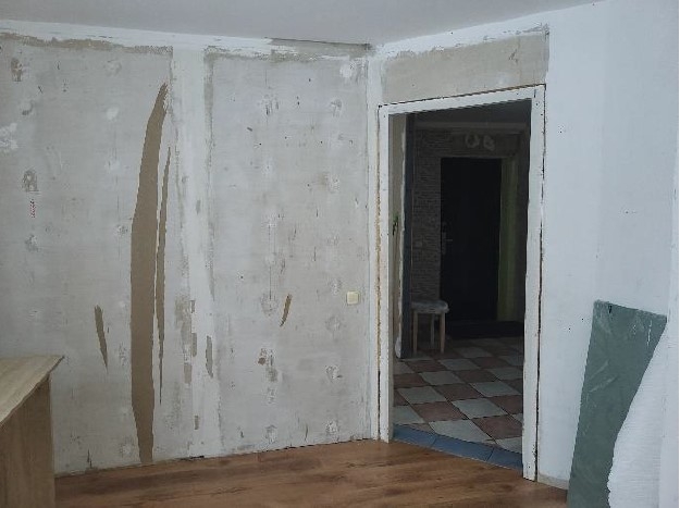 Istaba ar durvīm un noplēstām tapetēm