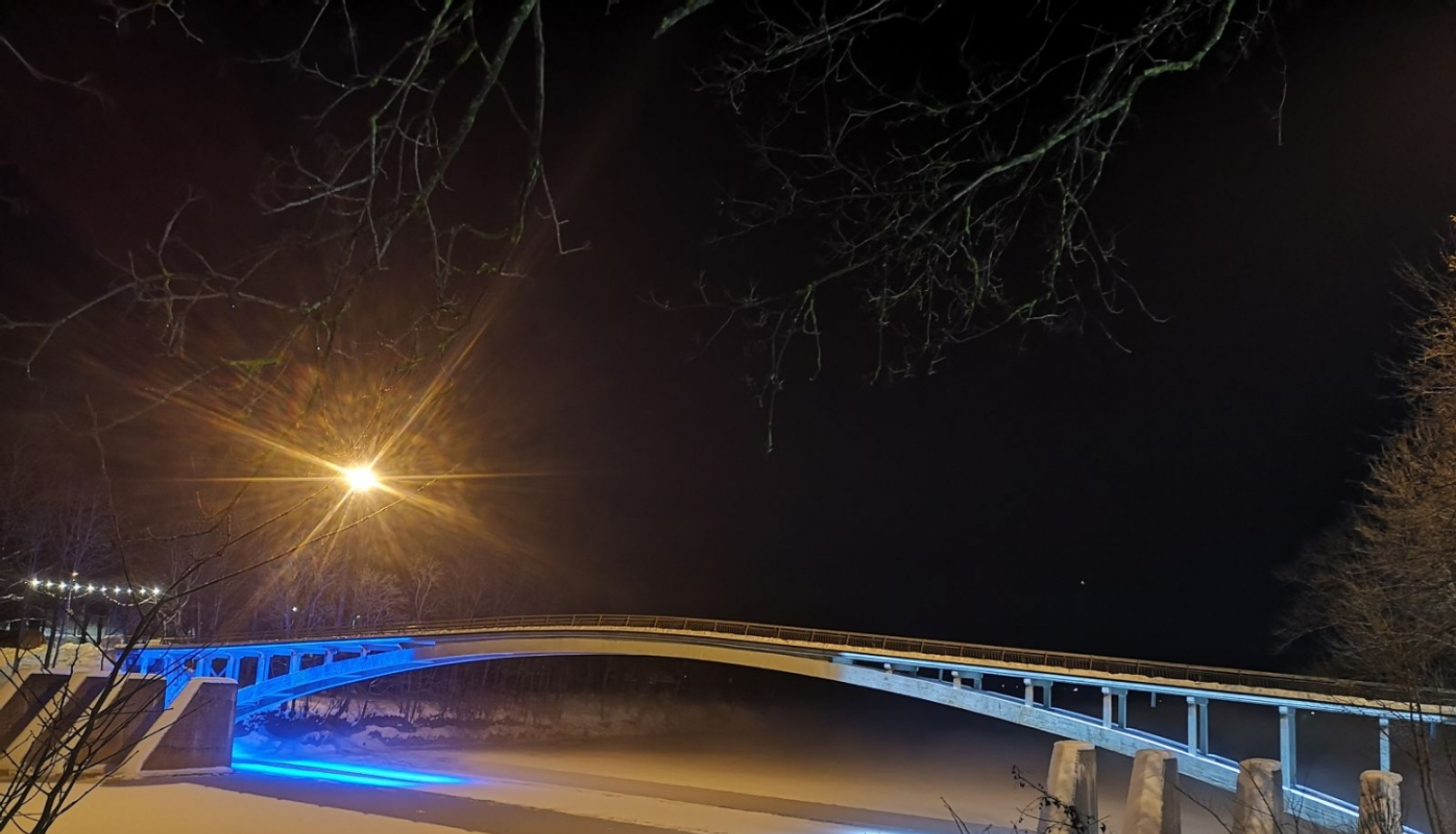 Igaunijas karoga krāsās izgaismots lokveida gājēju tilts