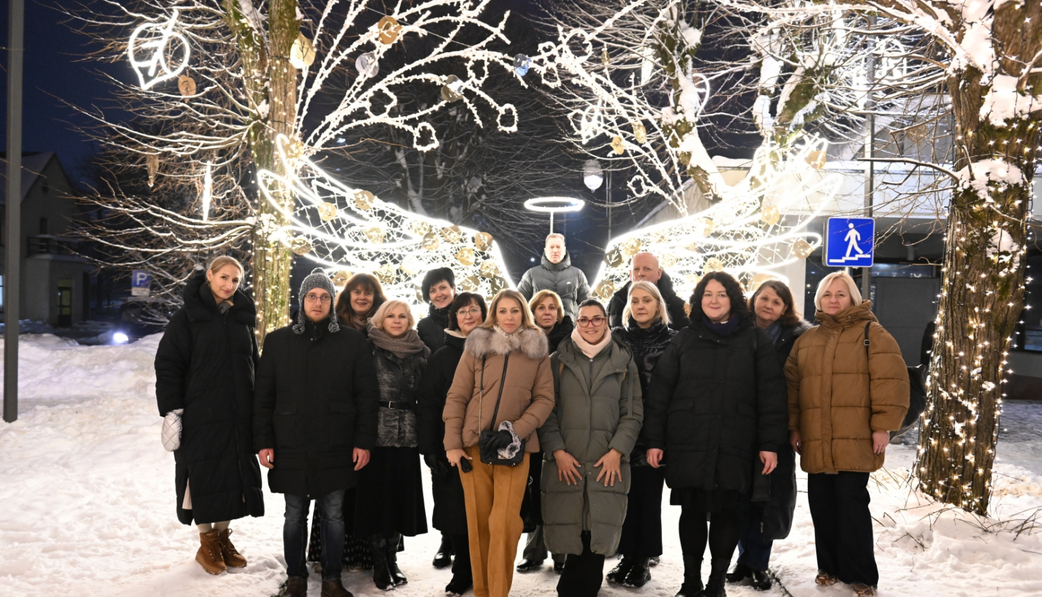 Kelmes delegācijas kopbilde gaismas instalācijas ar eņģeļa spārniem