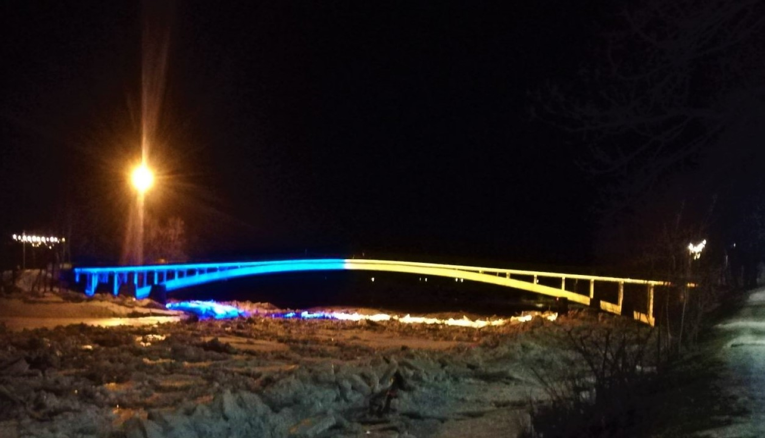 Gājēju tilts pār Ogres upi mirdz Ukrainas karoga krāsās