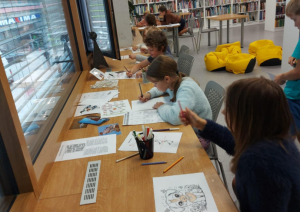 Ikšķiles pilsētas bibliotēkā realizēts neparasts projekts – ar kanisterapijas palīdzību veicināts bērnu lasītprieks. Bērni zīmē un krāso attēlus