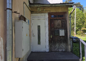 Ēkas siena ar elektrības sadales skapi un divām ieejas durvīm