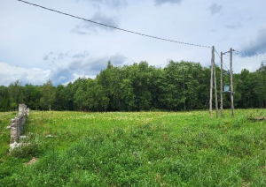Zemes gabals - pļava ar elektrības stabiem un mūra paliekām