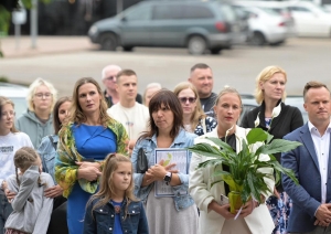 Cilvēki stāv ar ziediem rokās 23.08.2024.