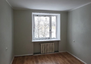 Istaba gaišos toņos ar logu un radiatoru