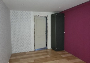 Istaba ar violetas krāsas sienu, durvīm un melnu skapi