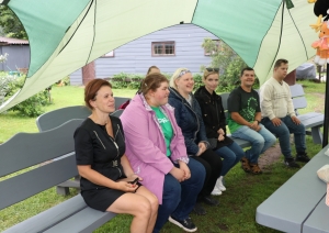 Sociāla uzņēmēja pie Zelta liepas darbinieki sēž uz soliņa 19.06.2024.