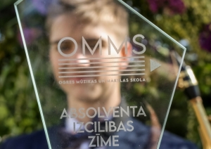Absolvents tur rokā Ogres Mūzikas un mākslas skolas Absolventa izcilības zīmi