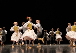 Skolēnu tautas deju skates dalībnieki uz skatuves tautas tērpos