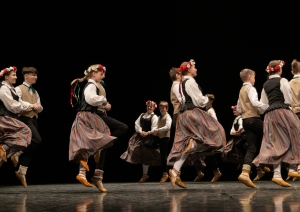 Skolēnu tautas deju skates dalībnieki uz skatuves tautas tērpos