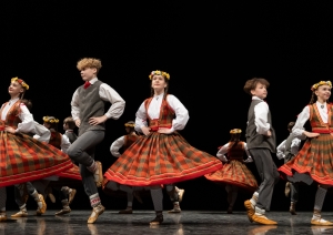 Skolēnu tautas deju skates dalībnieki uz skatuves tautas tērpos