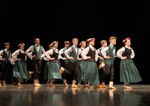 Skolēnu tautas deju skates dalībnieki uz skatuves tautas tērpos