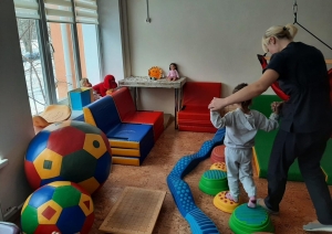 Ukrainas rehabilitācijas centrs bērniem ar īpašām vajadzībām “Atdzimšana”, bērns staigā pa bumbām, vingrošanas telpa. 12.2023.  