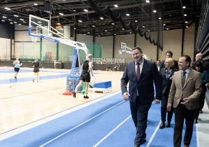 Tikšanās dalībnieki iet pa sporta arēnas skrejceļu
