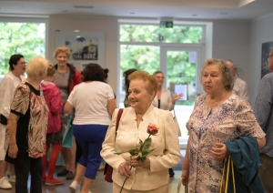 2 dāmas ar ziediem, fonā staigā citi cilvēki 23.08.2024.