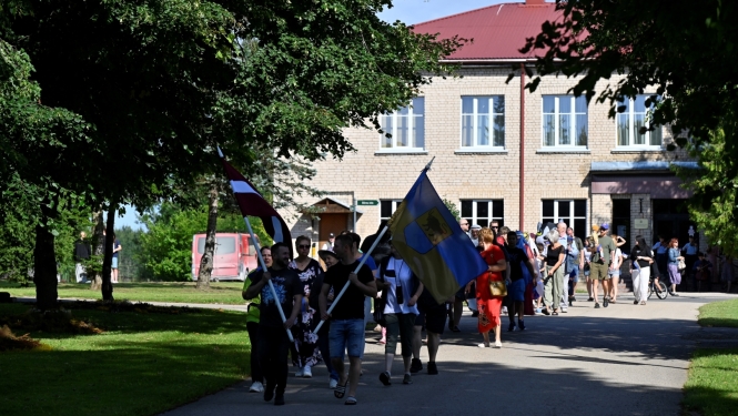 Svētku dalībnieki dodas tradicionālajā gājiena no Taurupes Tautas nama līdz skolai 