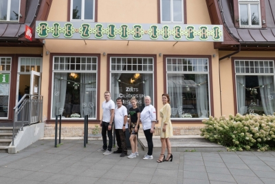 5 kafejnīcas Ogres Zelta liepa darbinieki pie kafejnīcas ēkas 08.2024.
