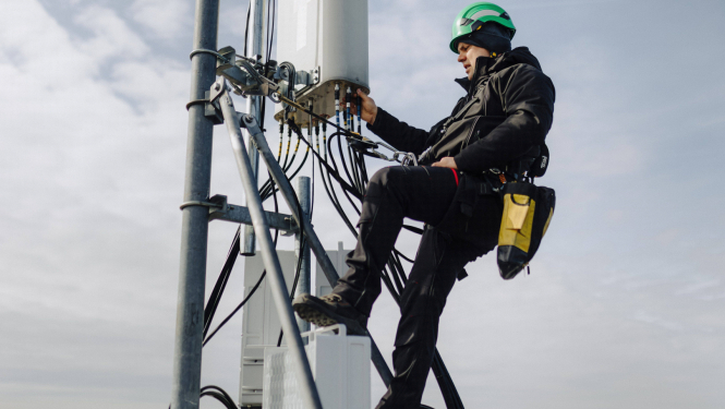 Bite Latvija publicitātes foto. Darbinieks telekomunikāciju tornī lielā augstumā