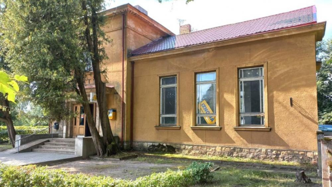 VAS "Latvijas Pasts" ēka ar koku un krūmu stādījumiem priekšplānā