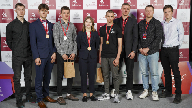 Astoņu Ogres tehnikuma audzēkņu kopbilde "Skills Latvia" fotostendā
