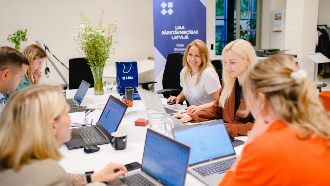 Latvijas Investīciju un attīstības aģentūras inkubācijas programmas rudens uzņemšana. Attēlā vairāki uzņēmēji ar atvērtiem planšetdatoriem, smaidīgi