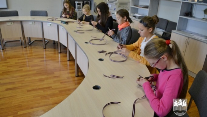 Skolēni griež un loka lentītes