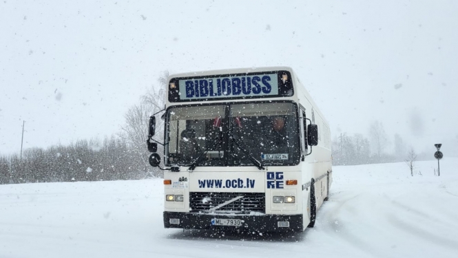 Ogres Centrālās bibliotēkas bibliobuss priekšpuse baltā krāsā, fonā ziema
