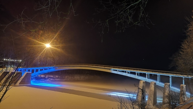 Igaunijas karoga krāsās izgaismots lokveida gājēju tilts