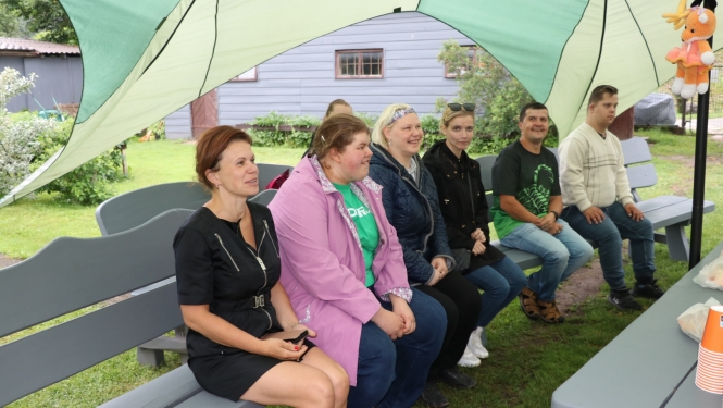 Sociāla uzņēmēja pie Zelta liepas darbinieki sēž uz soliņa 19.06.2024.