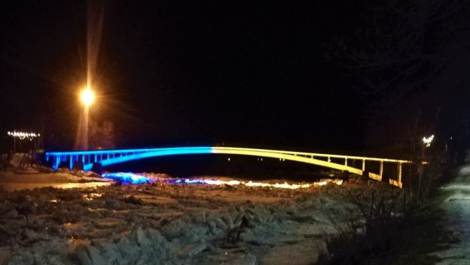 Gājēju tilts pār Ogres upi mirdz Ukrainas karoga krāsās