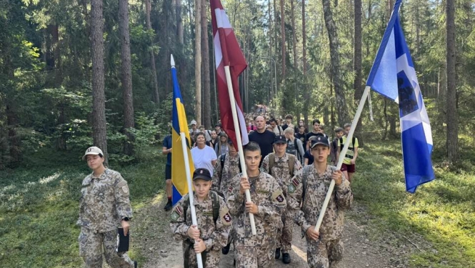 Vīrieši zemessardzes tērpos nes Latvijas, Ukrainas un Ogres novada karogus 06.09.2024.