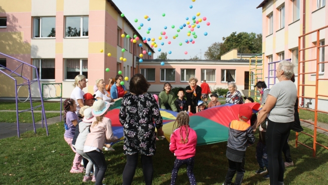 Bērni ar senioriem uz liela auduma met bumbas 09.2024.
