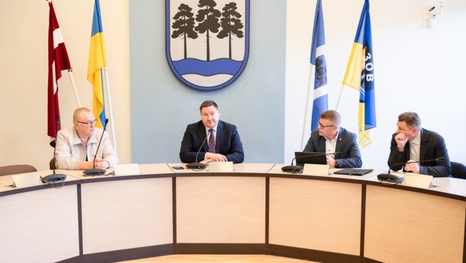 Egils Helmanis, Indulis Trapiņš un Latvijas Valsts ceļu pārstāvji sēž pie galda domes sēžu zālē