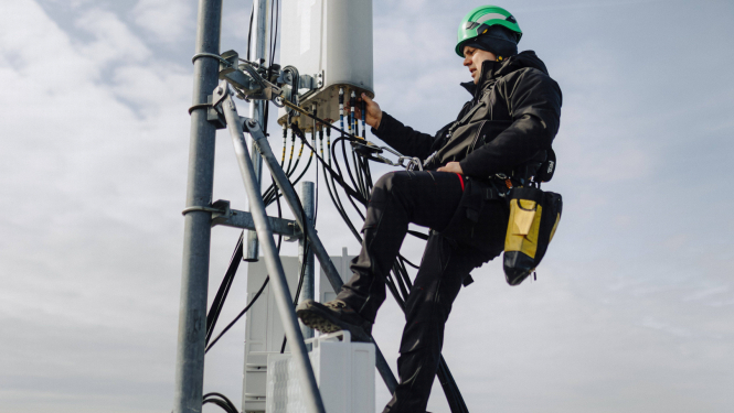 Bite Latvija publicitātes foto. Darbinieks telekomunikāciju tornī lielā augstumā