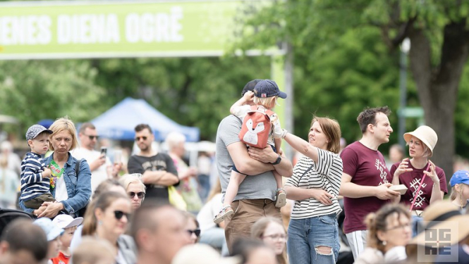 7. jūnijā Ogrē norisinājās tradicionālās ĢIMENES DIENAS svinības, kurās ar vērienīgu pasākumu programmu apmeklētāji varēja sajust kopā būšanas prieku un piedalīties kopīgās aktivitātēs visai ģimenei. Attēlā ģimenes ar bērniem, fonā baneris ar uzrakstu - Ģimenes diena Ogrē