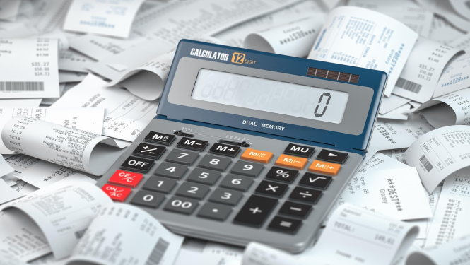 Kalkularors, kura ekrānā redzams cipars 0, uz čeku kaudzes