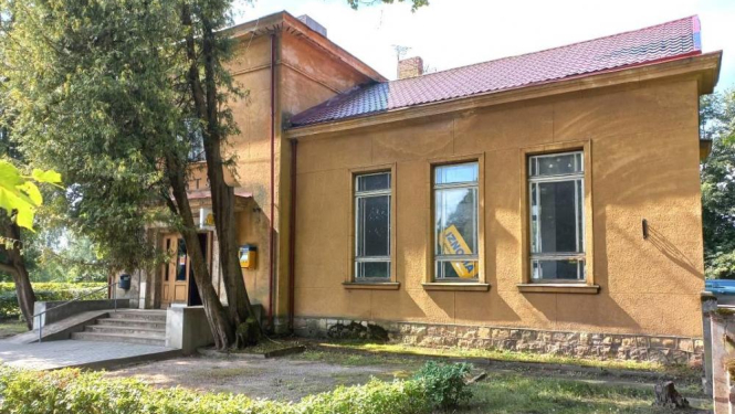 VAS "Latvijas Pasts" ēka ar koku un krūmu stādījumiem priekšplānā