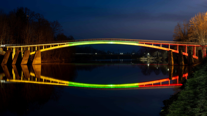 Lietuvas karoga krāsās izgaismotais gājēju tilts pār Ogres upi