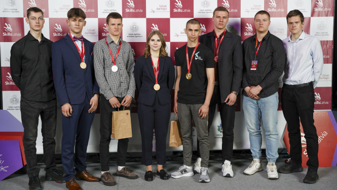Astoņu Ogres tehnikuma audzēkņu kopbilde "Skills Latvia" fotostendā