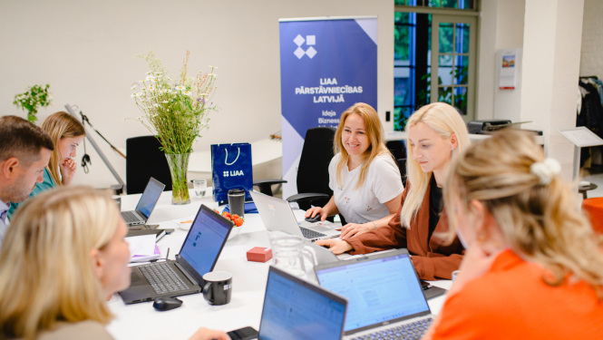 Latvijas Investīciju un attīstības aģentūras inkubācijas programmas rudens uzņemšana. Attēlā vairāki uzņēmēji ar atvērtiem planšetdatoriem, smaidīgi