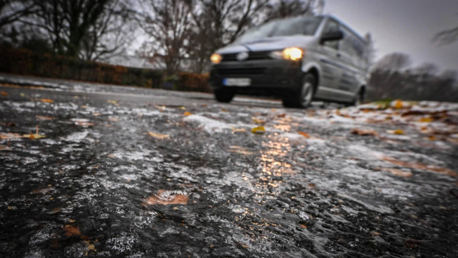 Apledojis ceļš rudenī, automašīna, ledū iesalušas krāsainas rudens lapas