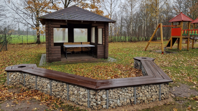 No akmeņiem un koka veidots dizaina sols pie Zaļās klases