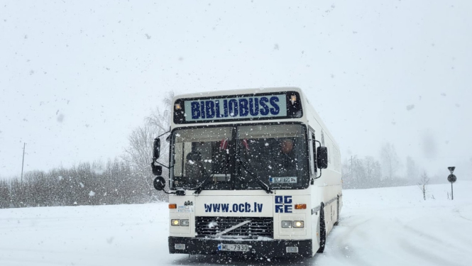 Ogres Centrālās bibliotēkas bibliobuss priekšpuse baltā krāsā, fonā ziema