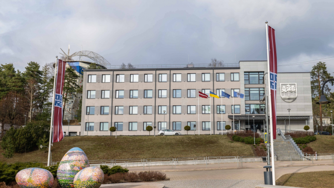 Domes ēka ar Lieldienu rotājumiem priekšplānā